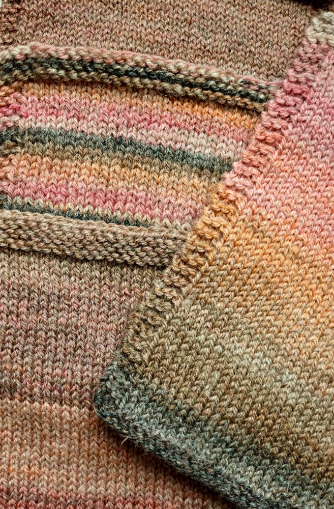 Four knitted swatches of handspun yarn. On the left, one is very blended in colour, the middle one contains short stripes and in the bottom one half the swatch is dark, the other light. On the right is a gradient which looks like a sunset. Dark brown at the bottom, through orange to a pinky coral. 