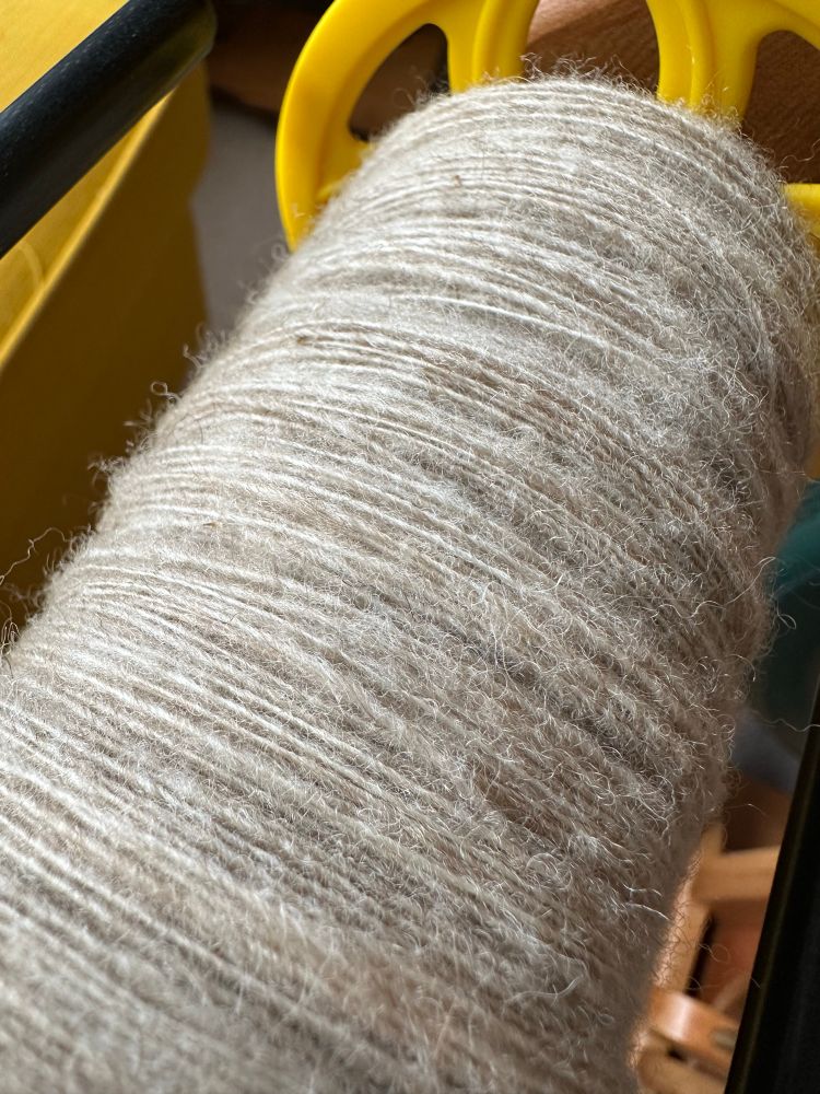 A close up of the yarn on the bobbin .