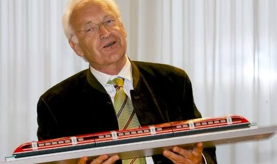 Ein altes Foto von Edmund Stoiber, in dem er einen roten Miniatur-Transrapid vor sich hält (als Anspielung an seine berüchtigte 10-Minuten-Rede).