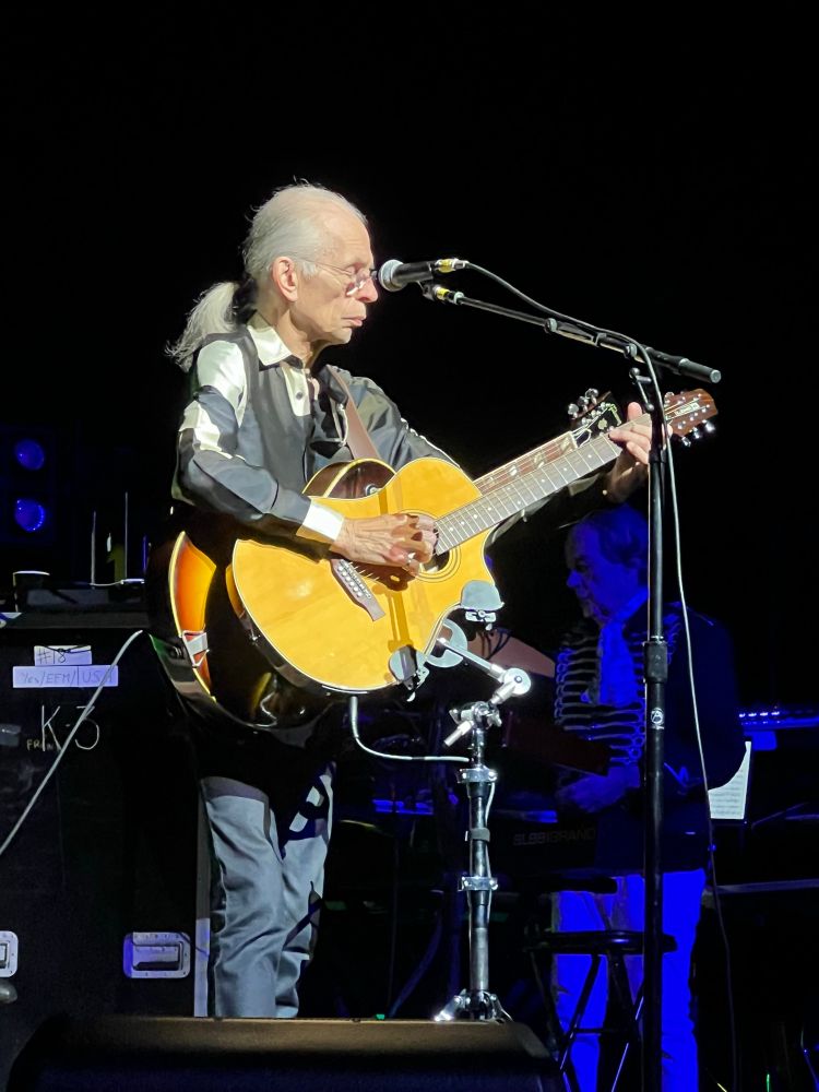 Steve Howe of Yes playing the guitar on stage. 