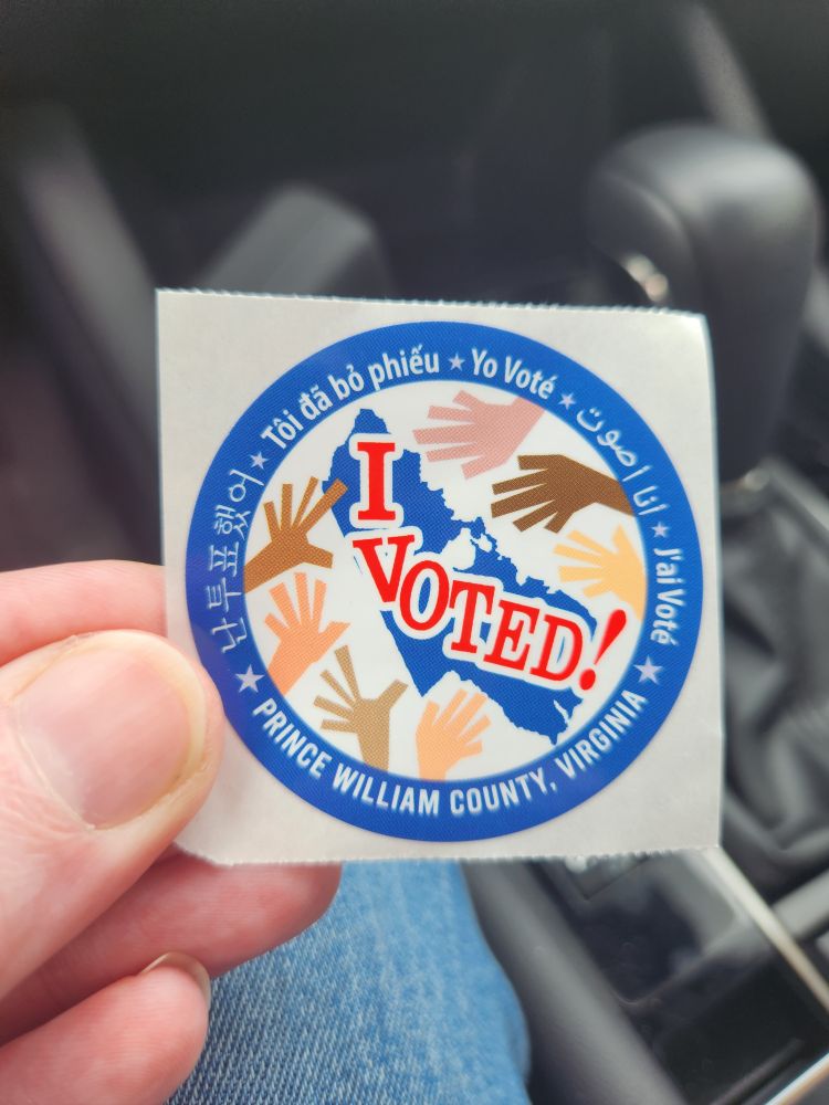 A sticker with the words I voted in Japanese, Thai, English, Arabic, and French from Prince William County Virginia.