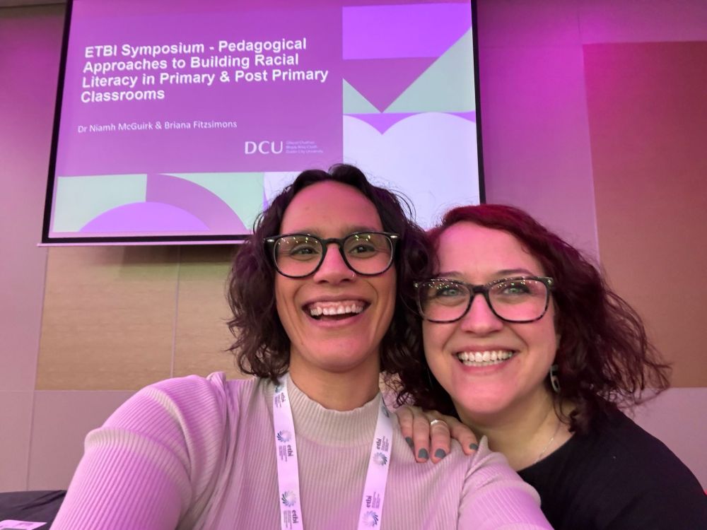 A photo of Briana Fitzsimons and Niamh McGuirk posing and smiling in front of their ppt title slide