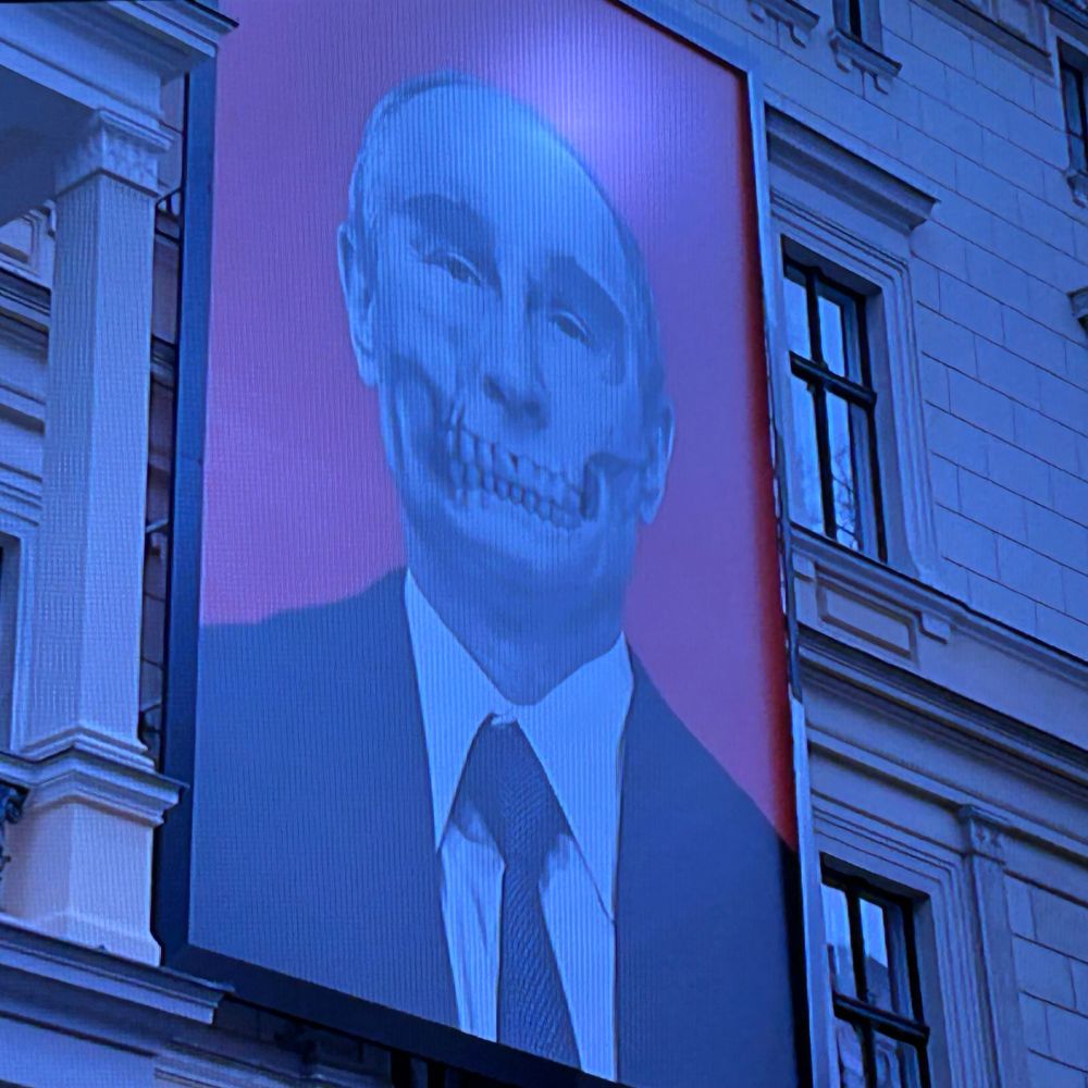 le visage de Poutine sur un bâtiment, le portrait fait dans les 10 mètre des haut. la mâchoire est celle d'un squelette 