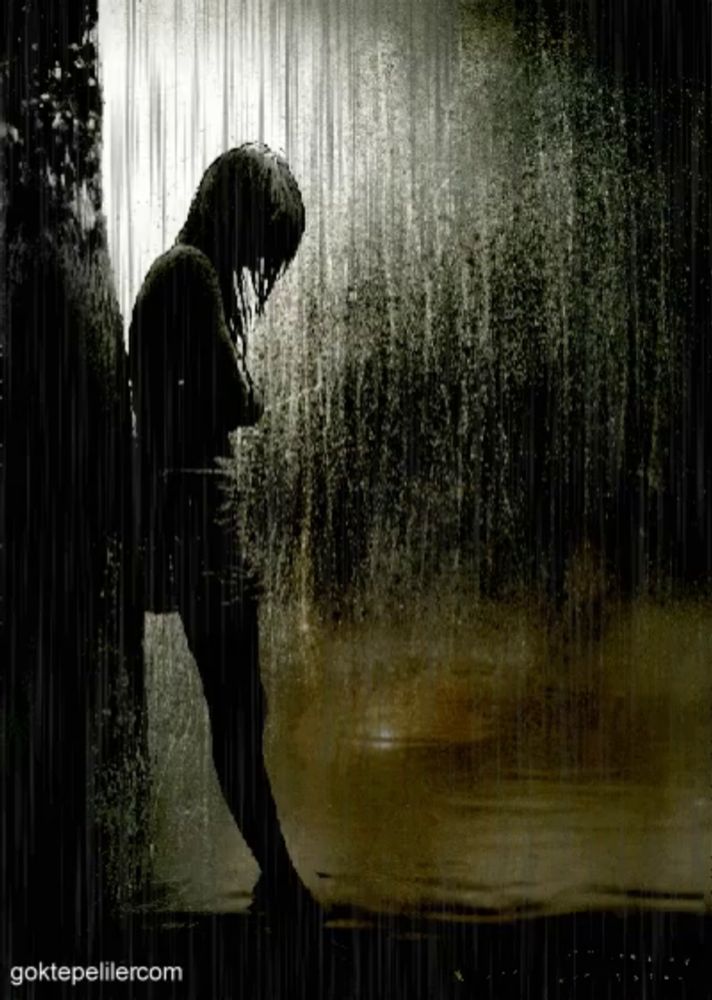 a silhouette of a person standing in the rain with the website goktepeliler.com in the corner