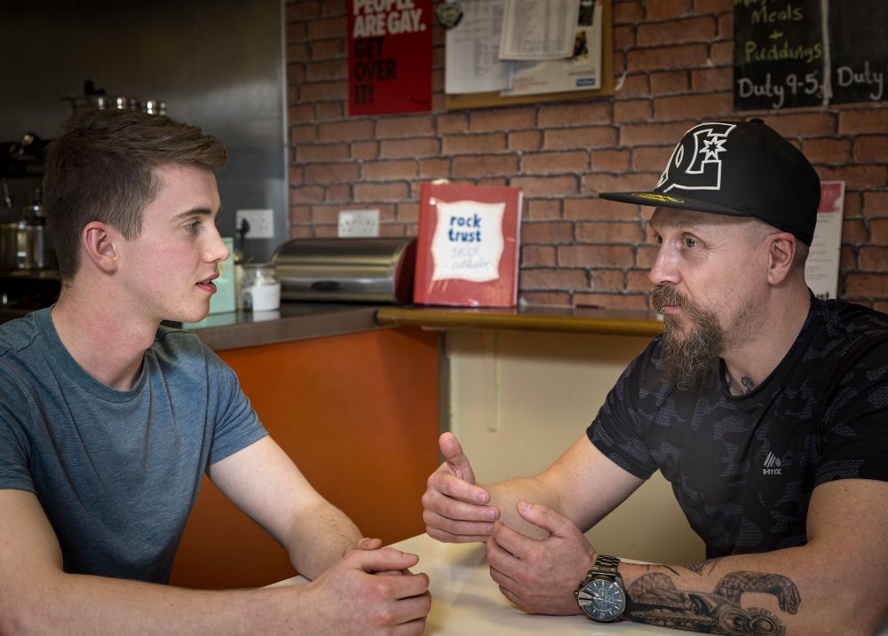 Young person and project worker having a relaxed conversation at Rock Trust Youth Housing Hub in Edinburgh.