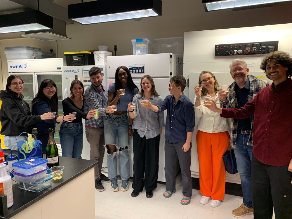 Members of the Moreau Lab and Chloe's parents toasting Chloe