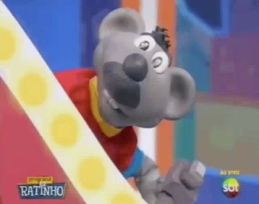 a cartoon mouse is wearing a red shirt and holding a nut .