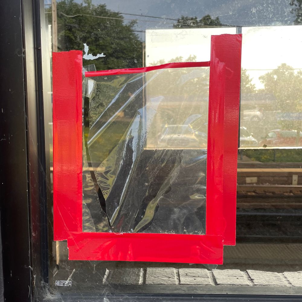 Photo of a square made w red duct tape on a window