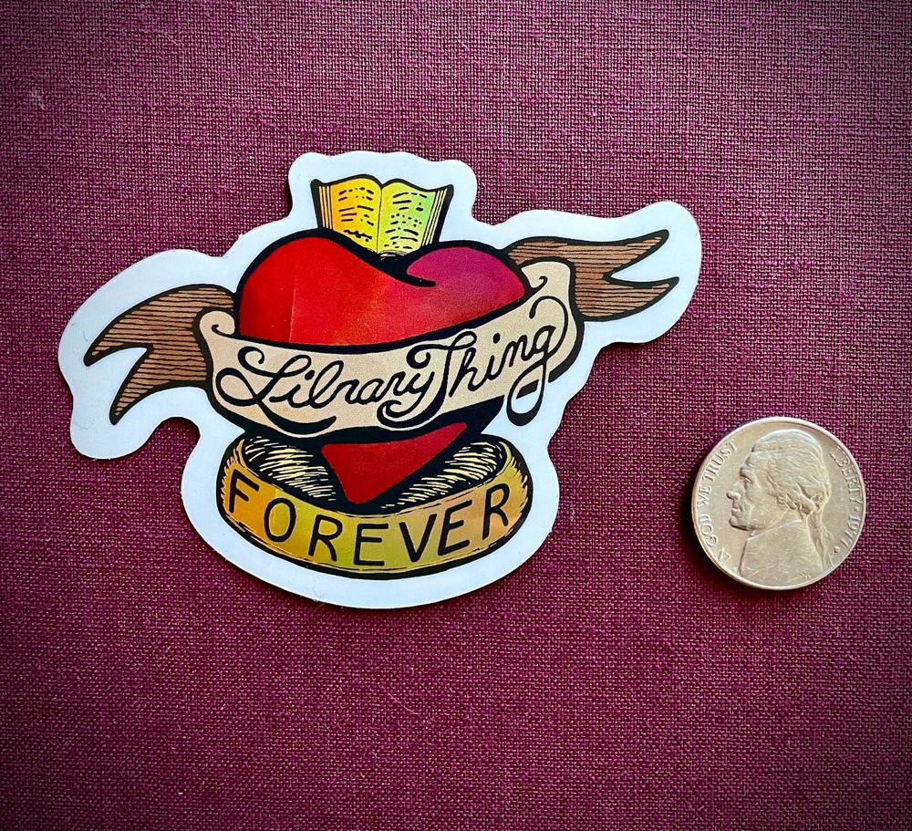 A photography of a LibraryThing Forever sticker, next to a nickel.