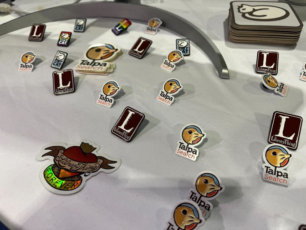A photography of LibraryThing, Talpa Search and TinyCat stickers and pins.