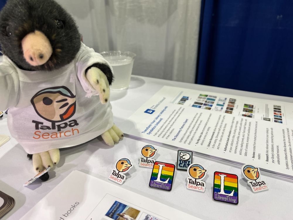A photograph of our Talpa Search mole, and some LibraryThing, Talpa and TinyCat stickers and pins.