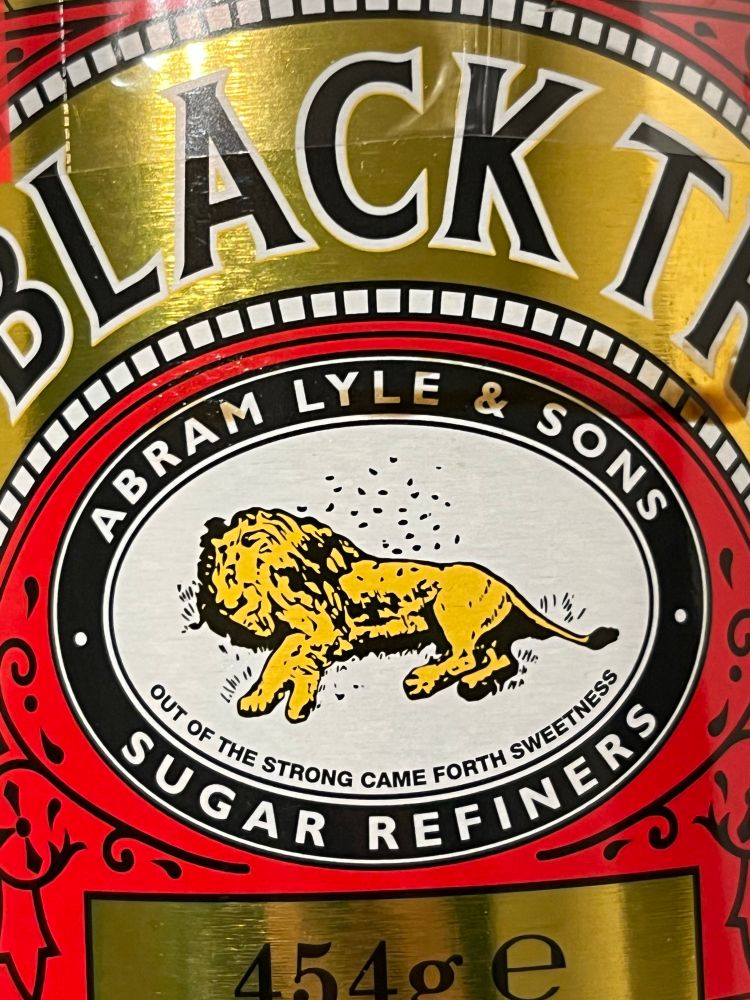 Close up of the Tate & Lyle logo. It’s a dead lion with a load of bees nesting in its abdomen. Yes really. Underneath is is the legend “out of the strong came forth sweetness”. 