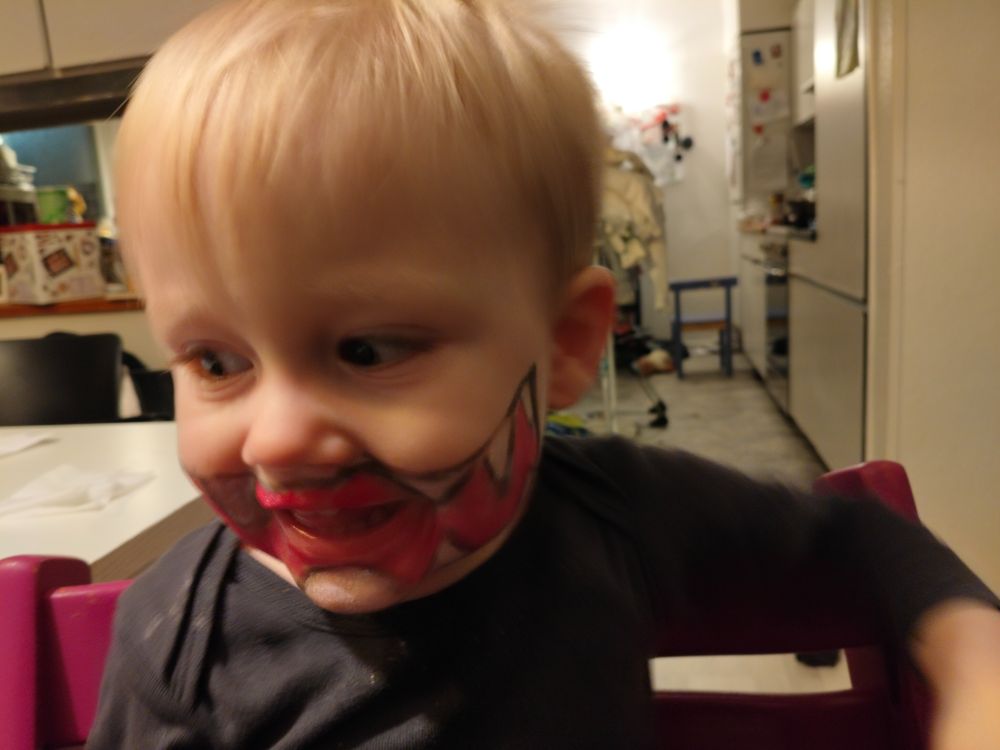 little man, with big teeth in a huge mouth, painted on with halloween makeup