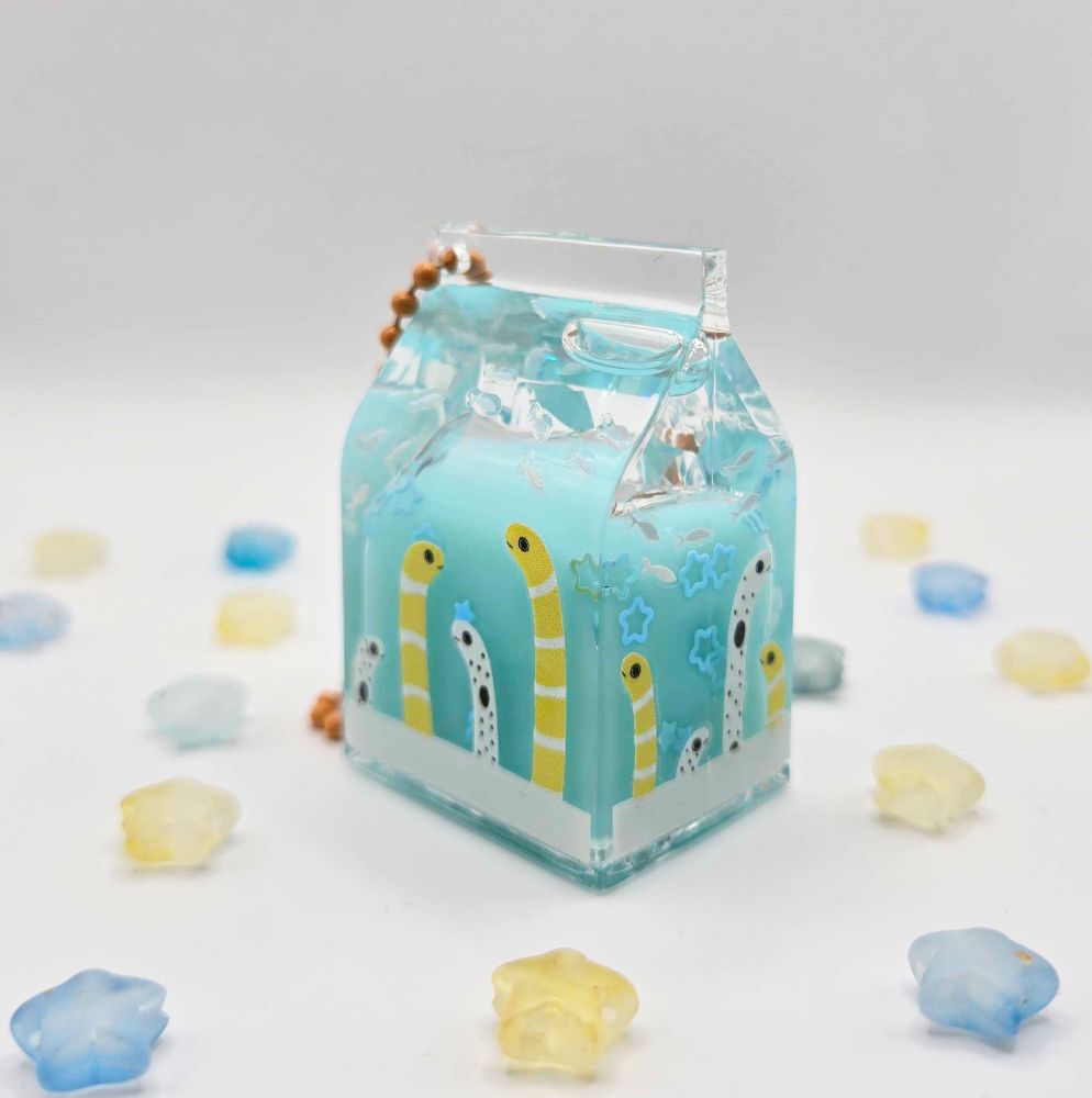 milk carton shaped charm with blue liquid inside and garden eel stickers around it!
