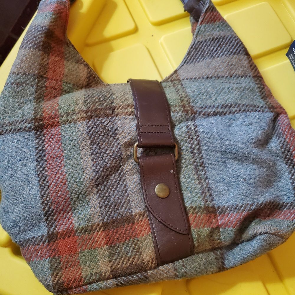 A blue, brown, red, beige, green plaid wool boho bag from the gap with a leather or pleather handle and snap.