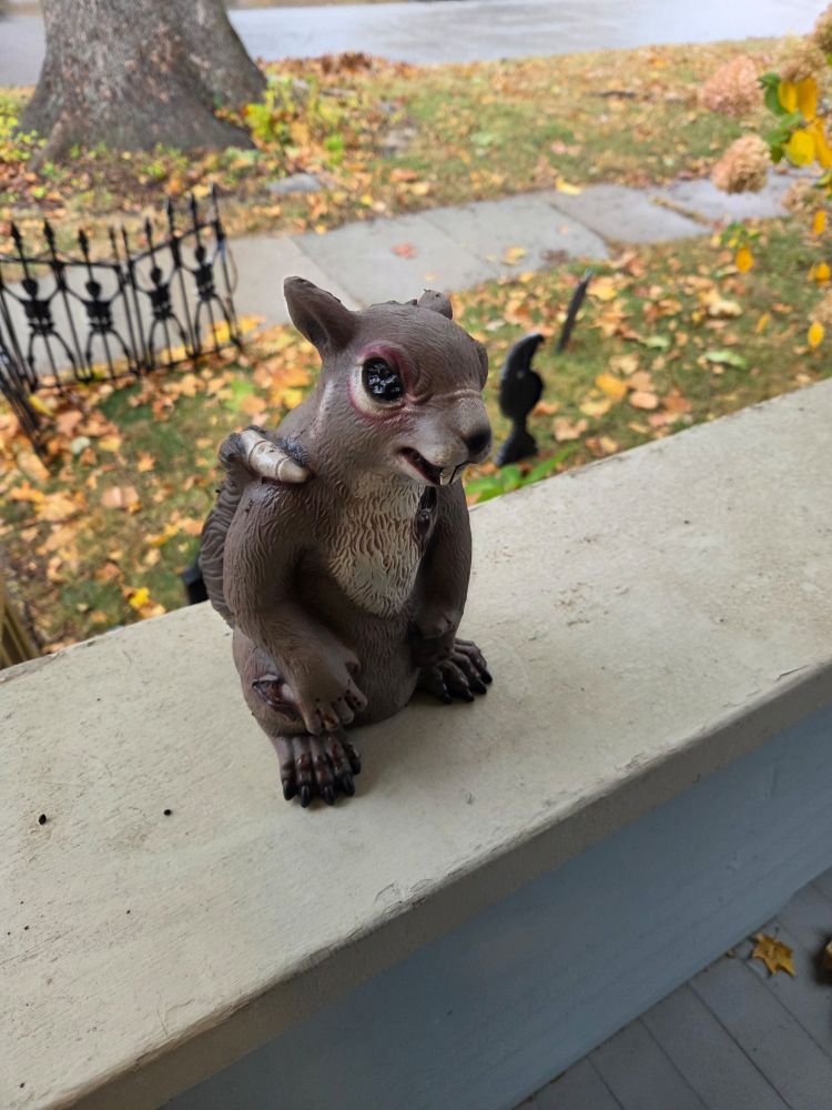 Zombie squirrel statue on porch rail