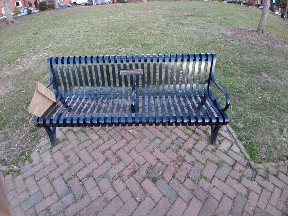 Public park bench in Fredericksburg Virginia with a divider down the middle added to keep homeless people from laying down