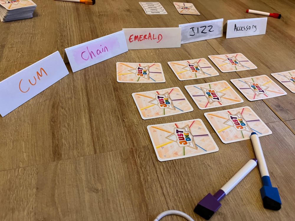 A game of Just One in progress, the guesses read CUM CHAIN EMERALD JIZZ ACCESSORY