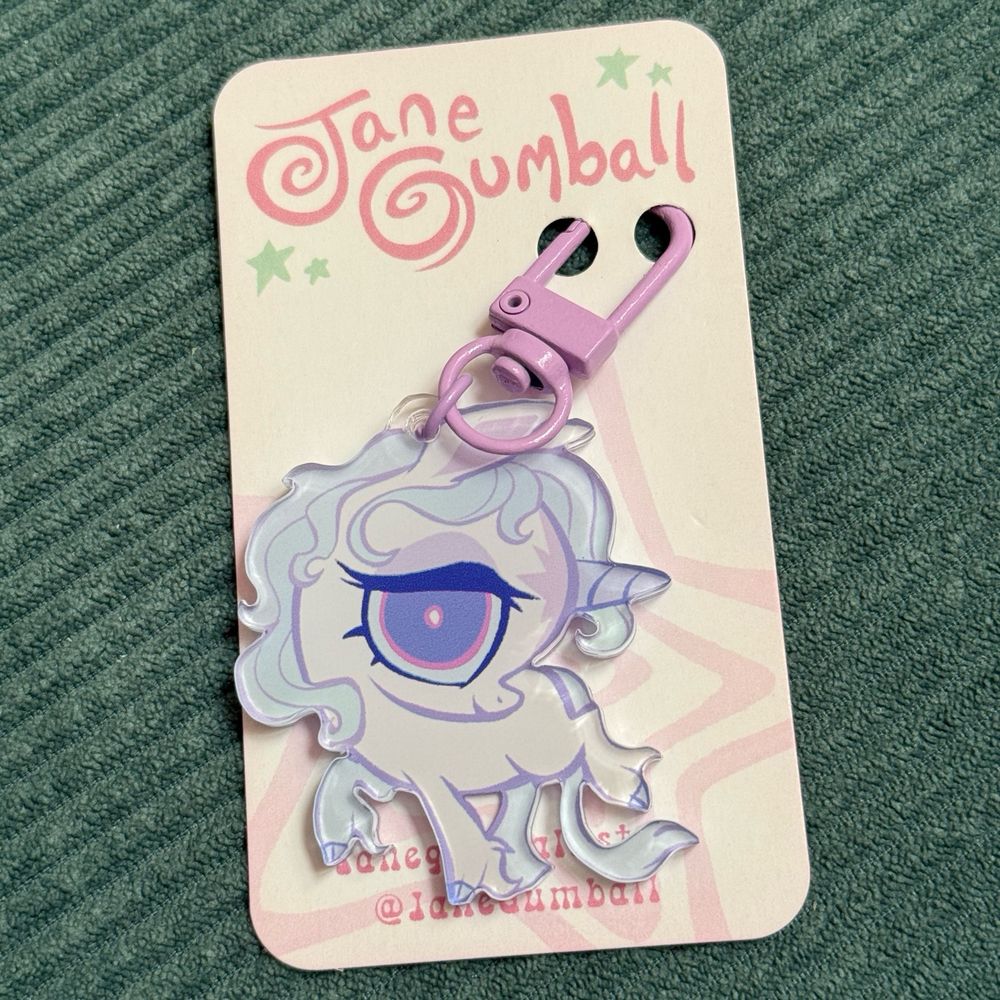 Acrylic keychain featuring an adorable rendition of Amalthea in her unicorn form from “The Last Unicorn”. Made by artist Jane Gumball.