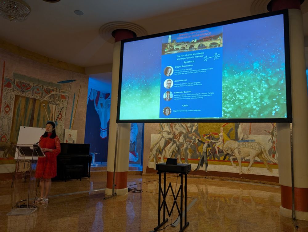 Dorothy Tse introducing the symposium with a screen showing the speakers and titles of their talks 