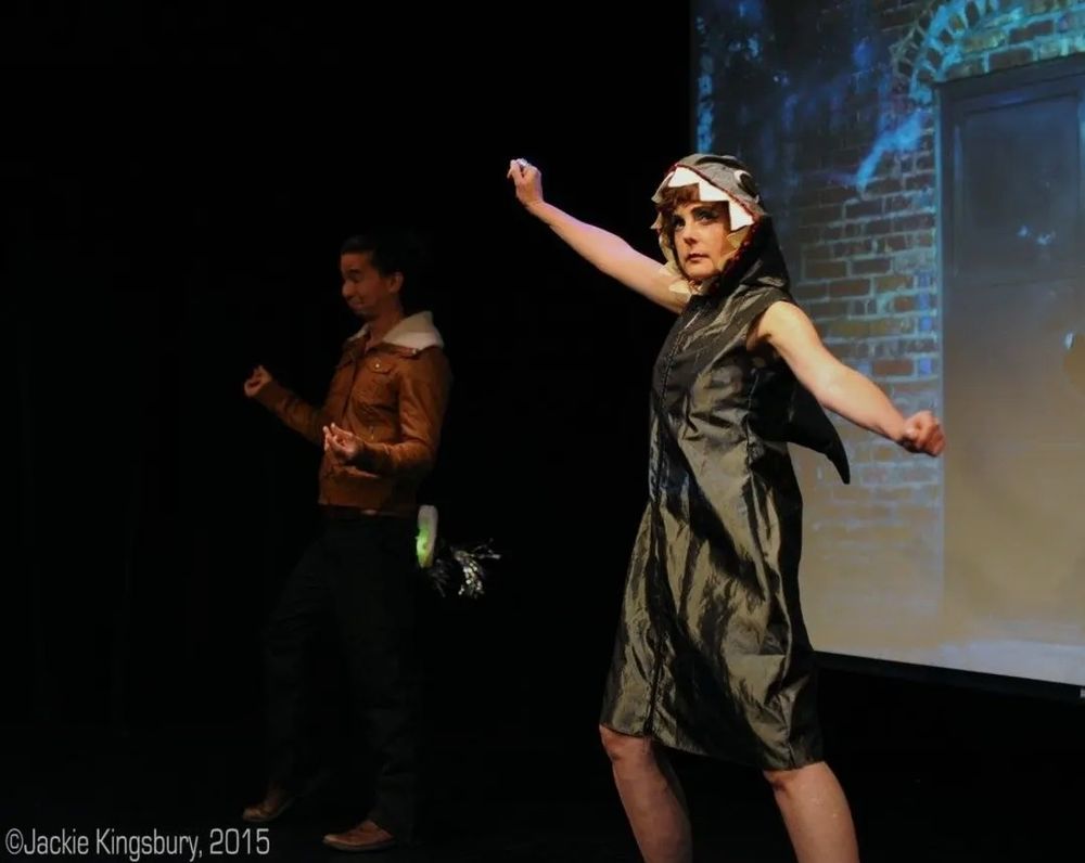 Person dressed as a jet pilot and person dressed as a shark onstage