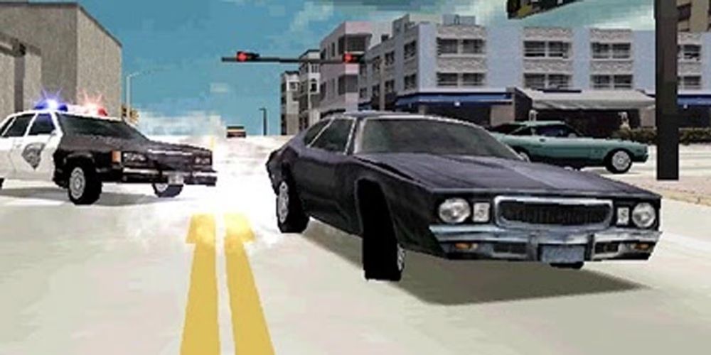 A black car being chased by a police car on a street in Miami.