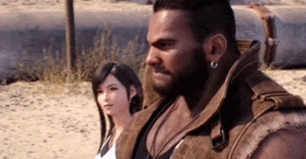 a man with a beard and earrings is standing next to a woman in the sand .