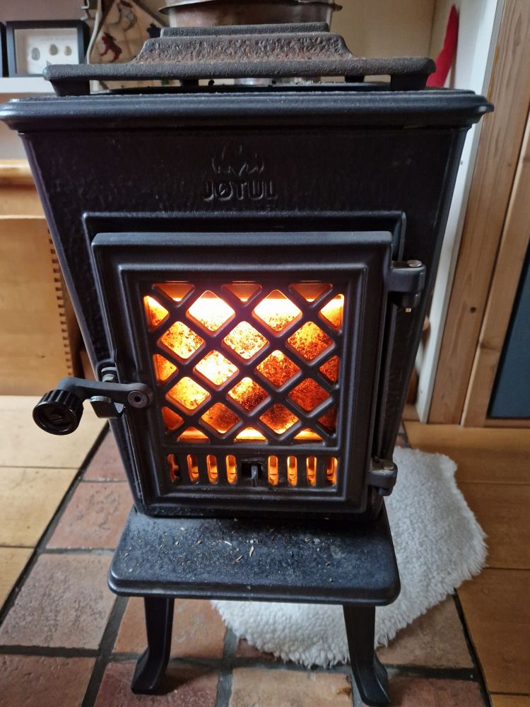 De kleinste Jøtul, een gietijzeren houtkacheltje uit Noorwegen. Het concept bestaat al >150 jr maar het binnenwerk verandert nog voortdurend om zo milieuvriendelijk te zijn.
Het uiterlijk is al die tijd hetzelfde gebleven, behalve dat er 25 jaar geleden een ruitje in het deurtje kwam. Dat maakt hem extra leuk.
