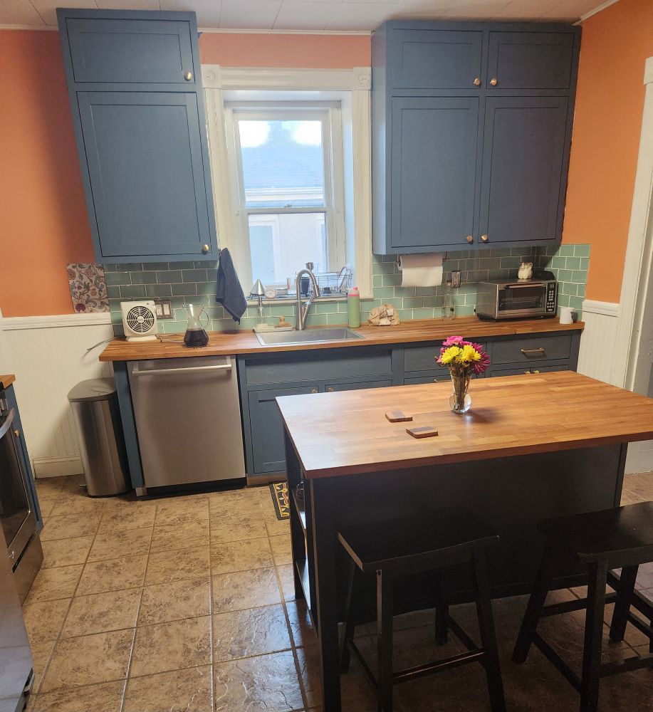 Shaker style inset kitchen cabinets with brass hardware knobs and pulls fully painted or with a primer coat of mountain blue linseed oil paint.