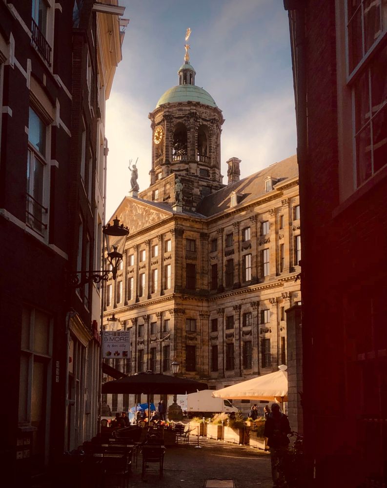 View on the Palace on Dam Square in Amsterdam early in the morning. Warm sunlight, dark shadows. Looks like a painting.
