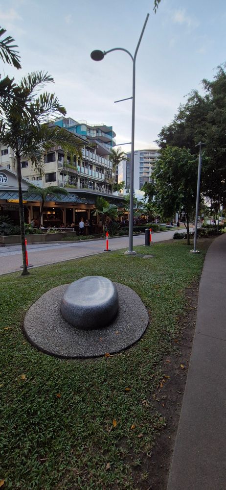 Footpath, a patch of grass, and a stone seat shaped like a hat
