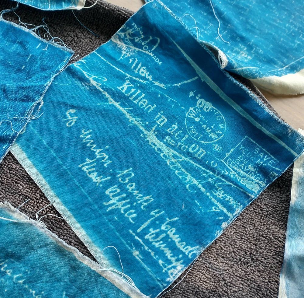 a blue cyanotype print of an envelope. Text on the envelope reads "Killed in Action Return to Sender" as well as a handwritten address, and cancelled stamps.
