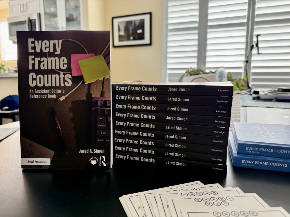 A stack of copies of the book Every Frame Counts, with one copy propped up on the stack.