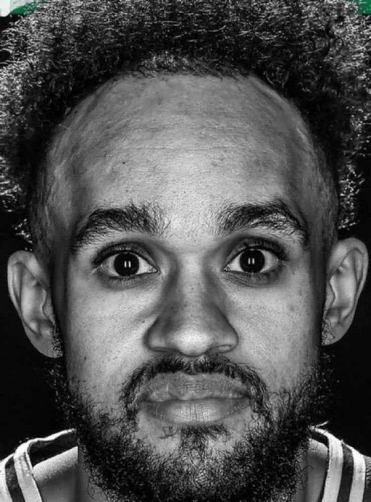 A black and white photo of Derrick White staring at the camera in utter torment