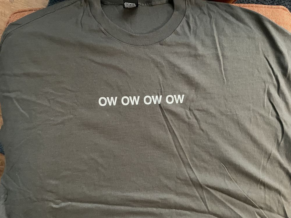 An olive colored tee-shirt with the phrase "ow ow ow ow" printed in light colored text.
