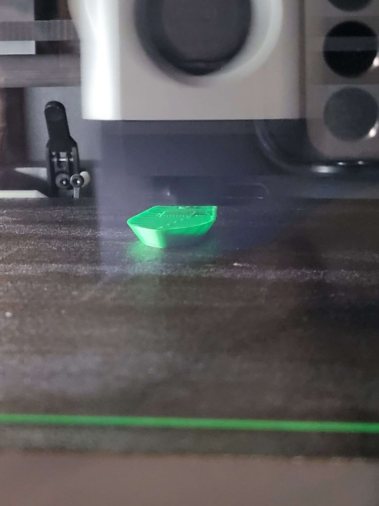 A 3D Printer printing a Green 3D Benchy Boat
