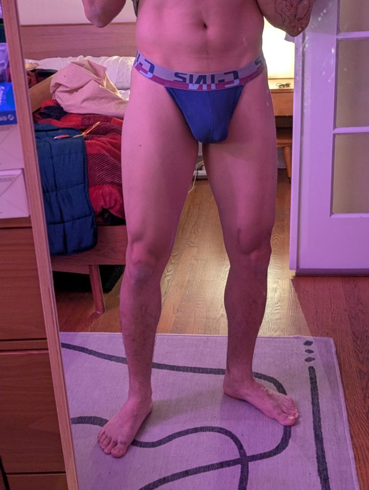 Front view of a man in a gray and blue thong 