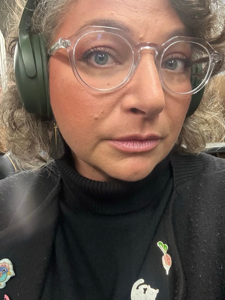 Selfie de femme blanche maquillé en rose et orange avec du mascara et des lunettes translucides 