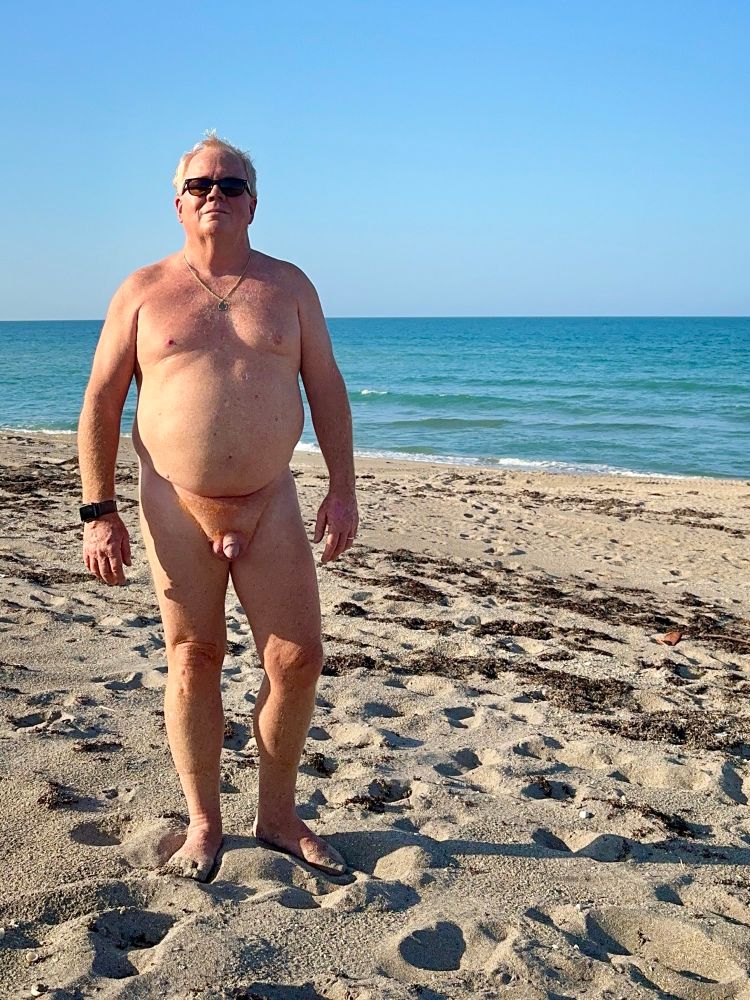 Chubby nude man on a sunny beach, living the life. He seems nice. 