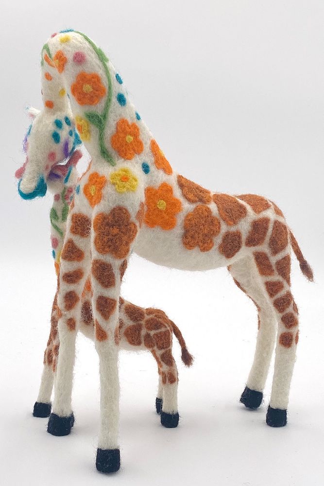 Reverse view of "Love Is Nurtured" - needle felted anththropomorphic giraffe sculpture depicts mother and child touching heads by Lynn Wartski.  Giraffe pattern morphs from natural to stylized botanical shapes and colors.  Pattern appears to pass from parent to child through touch.  11"x 8"x 5"