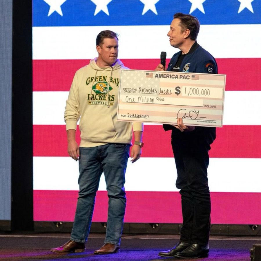 Elon Musk giving $1 million check to Nicholas Jacobs, a random voter. 