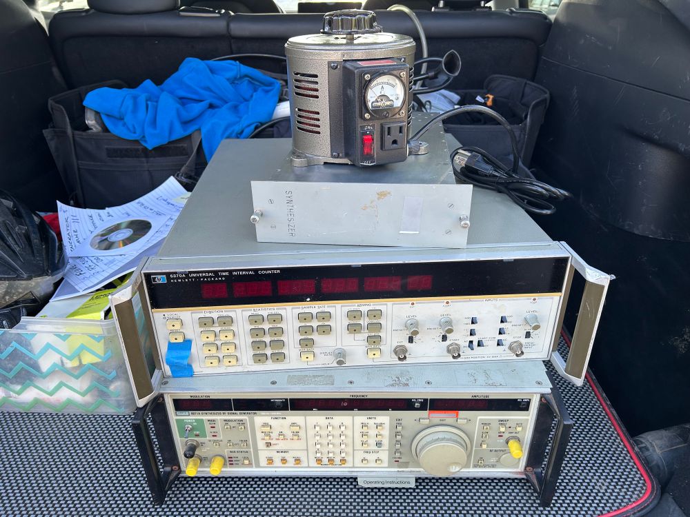 Variac, clock synthesizer, HP 5370A and Fluke 6071A stacked on top of each other in the trunk of my car. 
