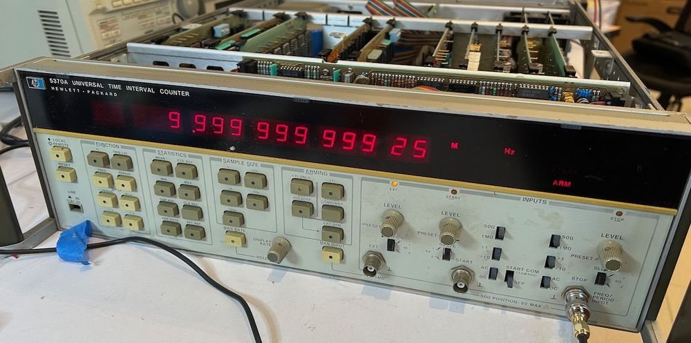 The HP 5370A displaying a measured frequency of 9,999,999.9925 MHz.