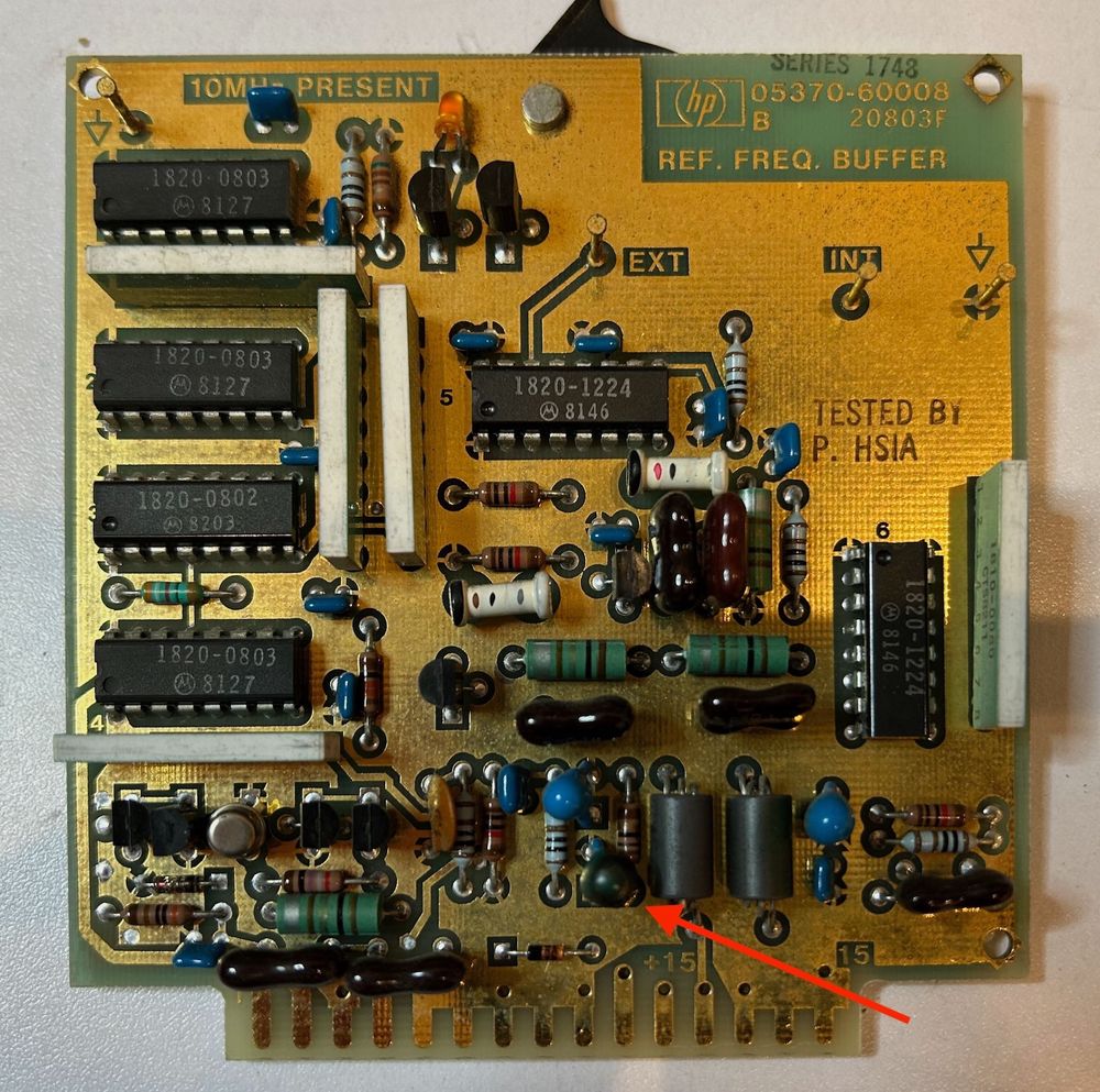 Reference frequency buffer PCB of an HP5370A. A red arrow points to a burnt capacitor.