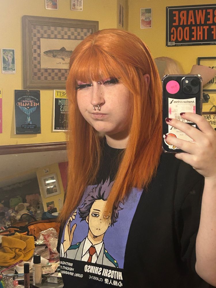 a picture of me in a wig i straightened. it’s very orange and my cheeks are puffed 
