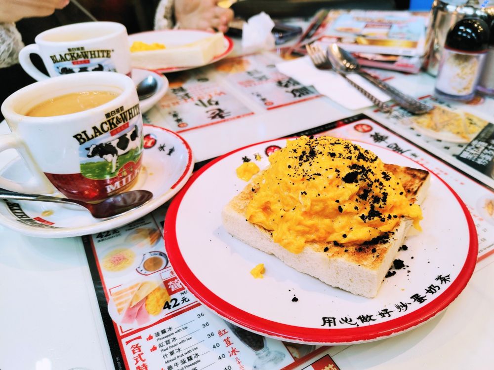 華星冰室の黒トリュフスクランブルエッグトーストとホットミルクティー。ミルクティーのソーサーは華星冰室の名入り。