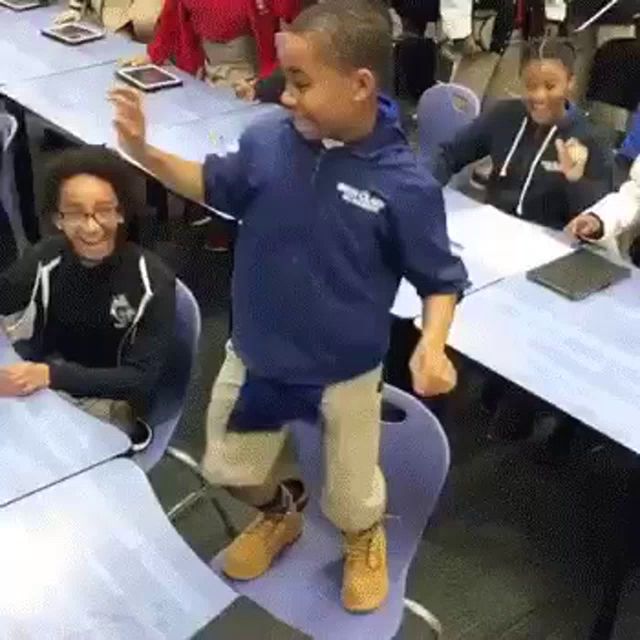 a young boy is dancing in a classroom with other children .