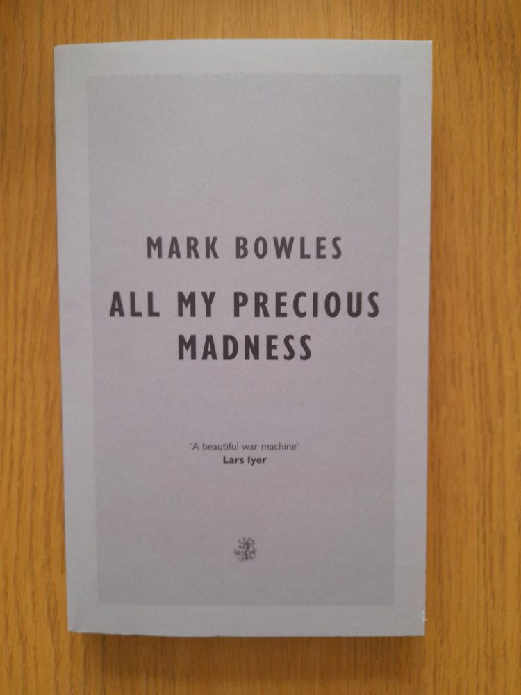 Cover of the book, 'All My Precious Madness' by Mark Bowles, pictured on a coffee table.