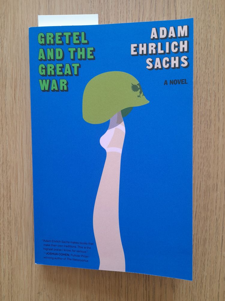 Cover of the book, Gretel and the Great War by Adam Ehrlich Sachs. On a blue background, a ballerina's leg points upwards, with a soldier's helmet balanced on top.