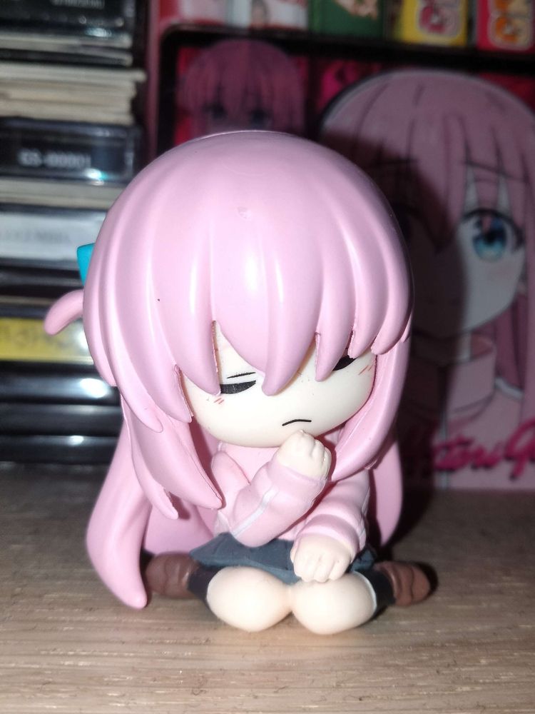 Small-size figure of Bocchi the Rock's character Hitori Goto on a bookshelf